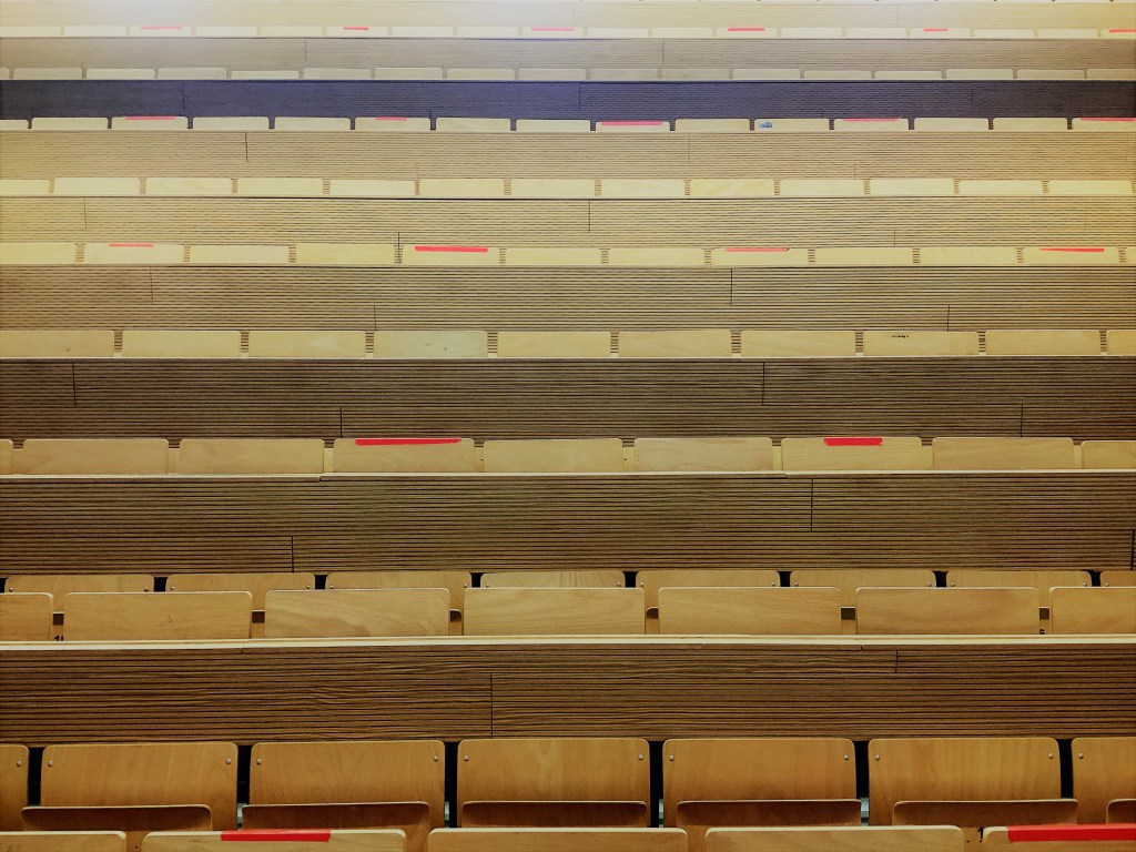 A close up of wooden seats in a lecture hall