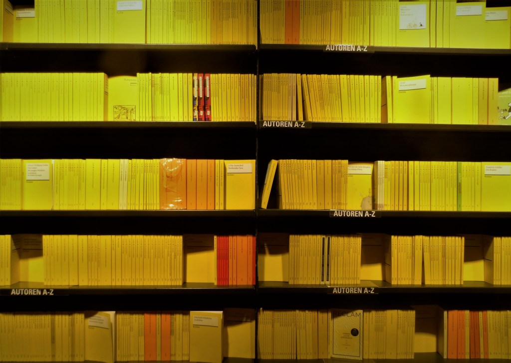 A bookshelves full of yellow Reklam books